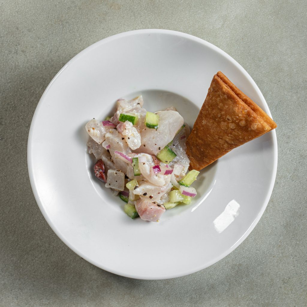 Crude fresh fish accompanied by pita crunch in a deep dish