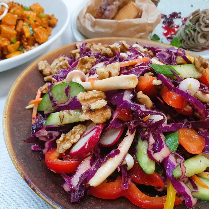 Asian salad with cabbage, cucumber, radish, gamba, carrot sticks, shimeji mushrooms and walnuts