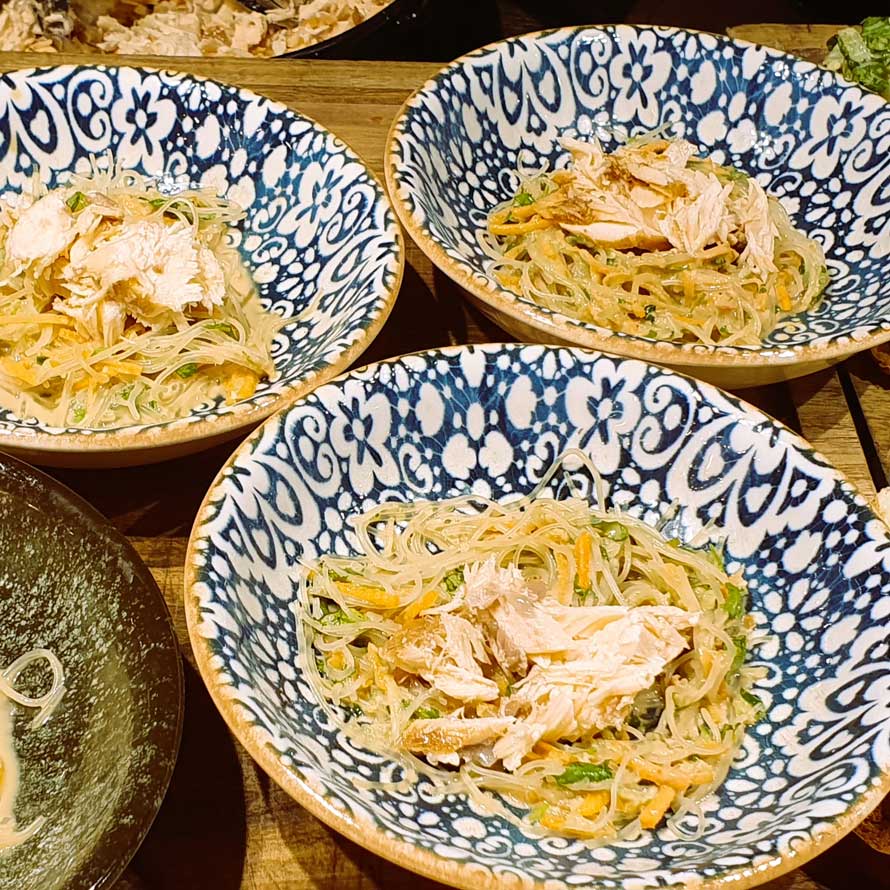 Soy-honey glazed salmon over cellophane noodles and satay sauce served in individual bowls