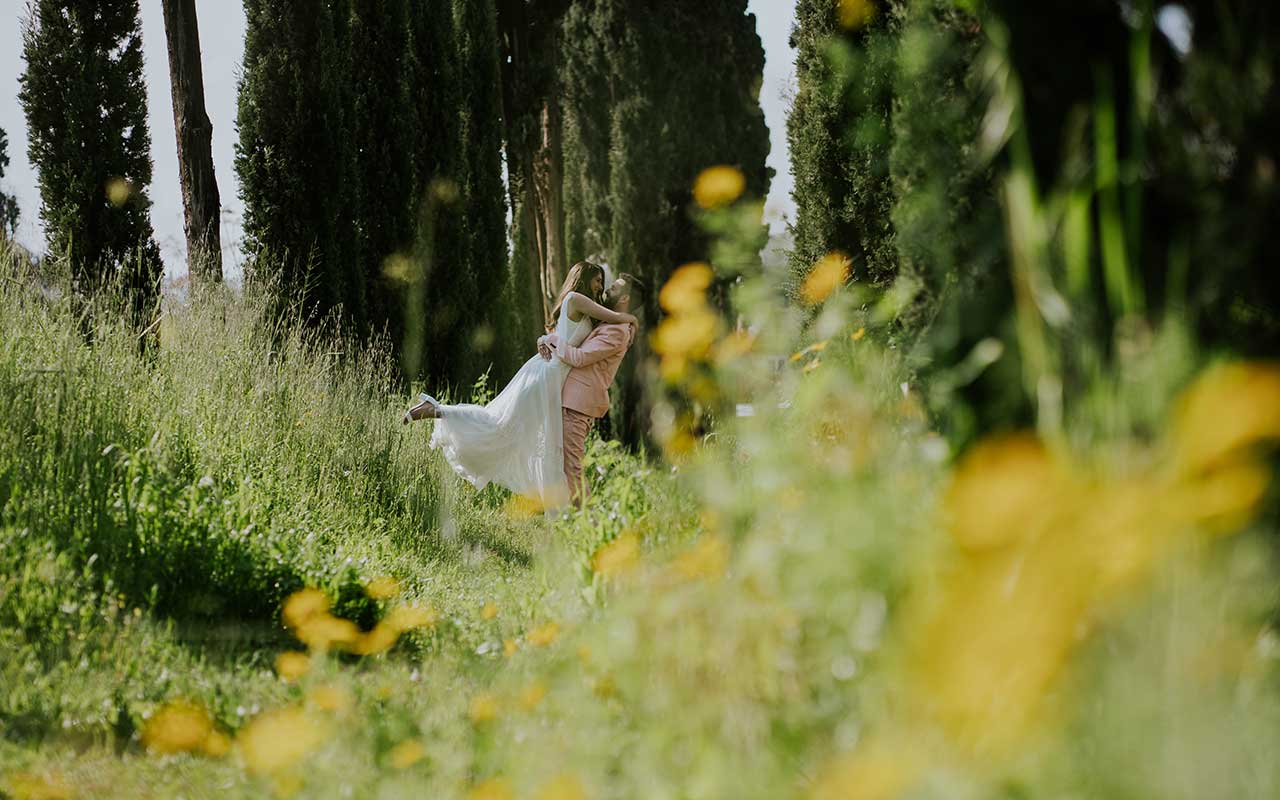 חתן מרים את הכלה בחיבוק בטבע