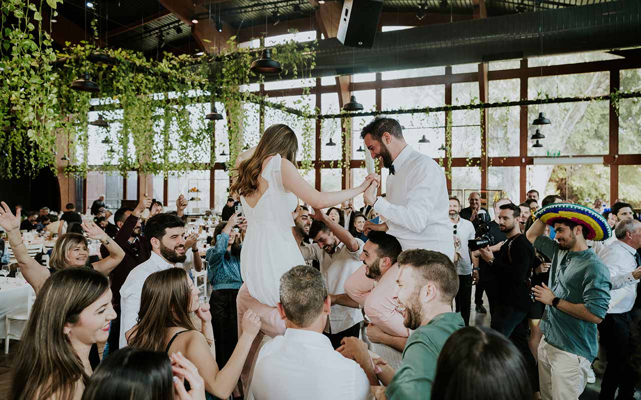 חתן וכלה נישים על כתפיים במסיבת חתונה בשישי צהריים