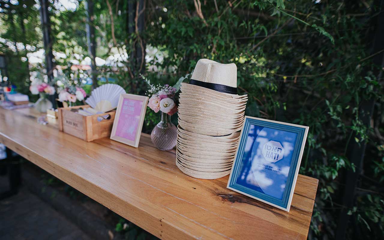 עמדה עם כובעים, מניפות, שלטים ופרחים