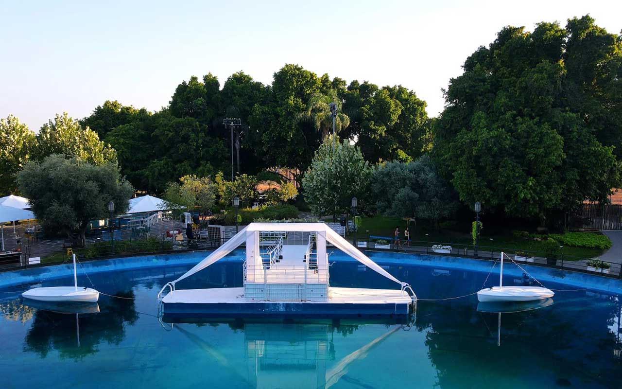 חופה לבנה על המים בגן ירוק שופע צמחיה